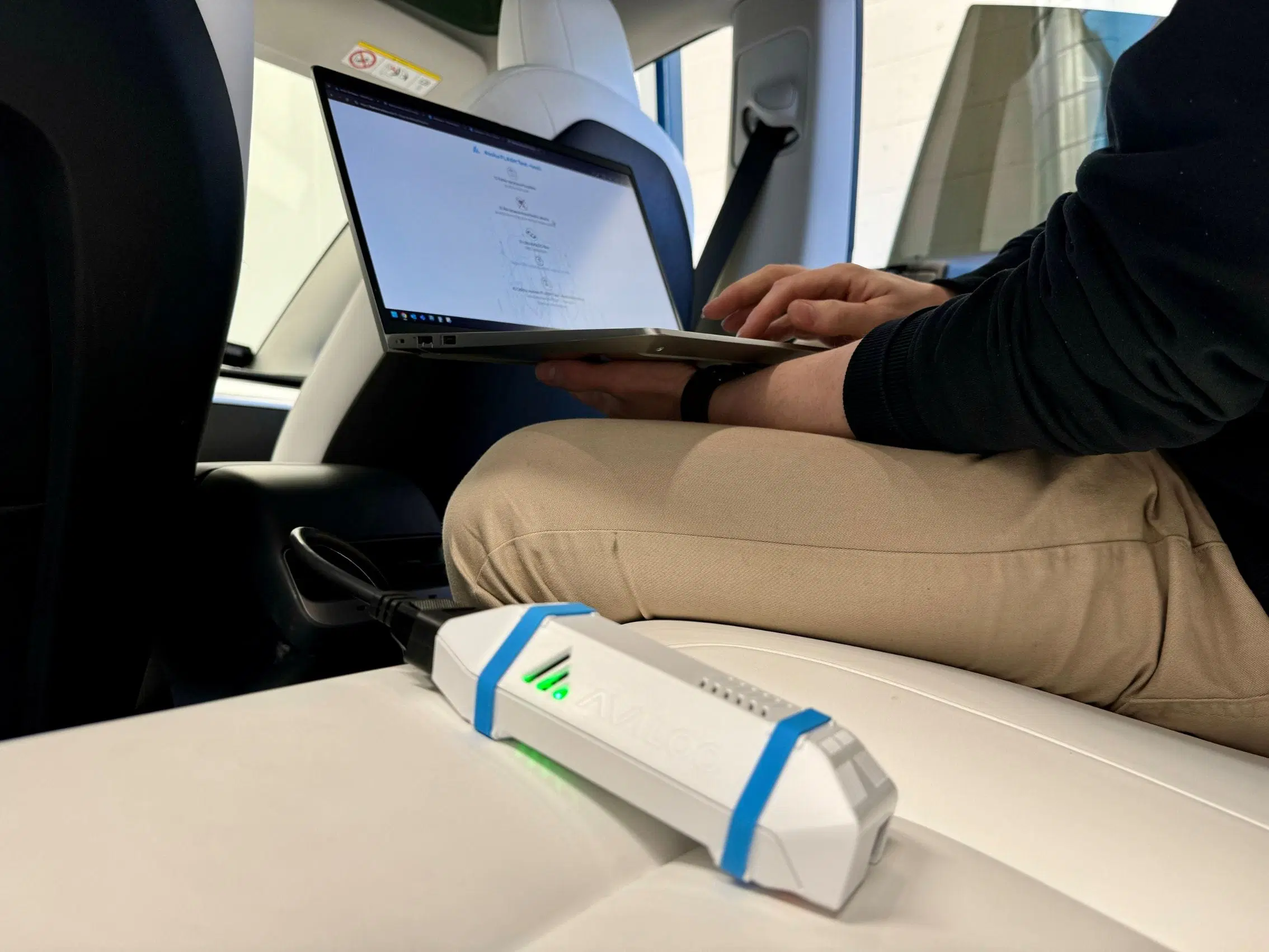 AVILOO Flash mérőeszköz és laptop egy elektromos autó utasterében, független hajtóakkumulátor-vizsgálat közben.