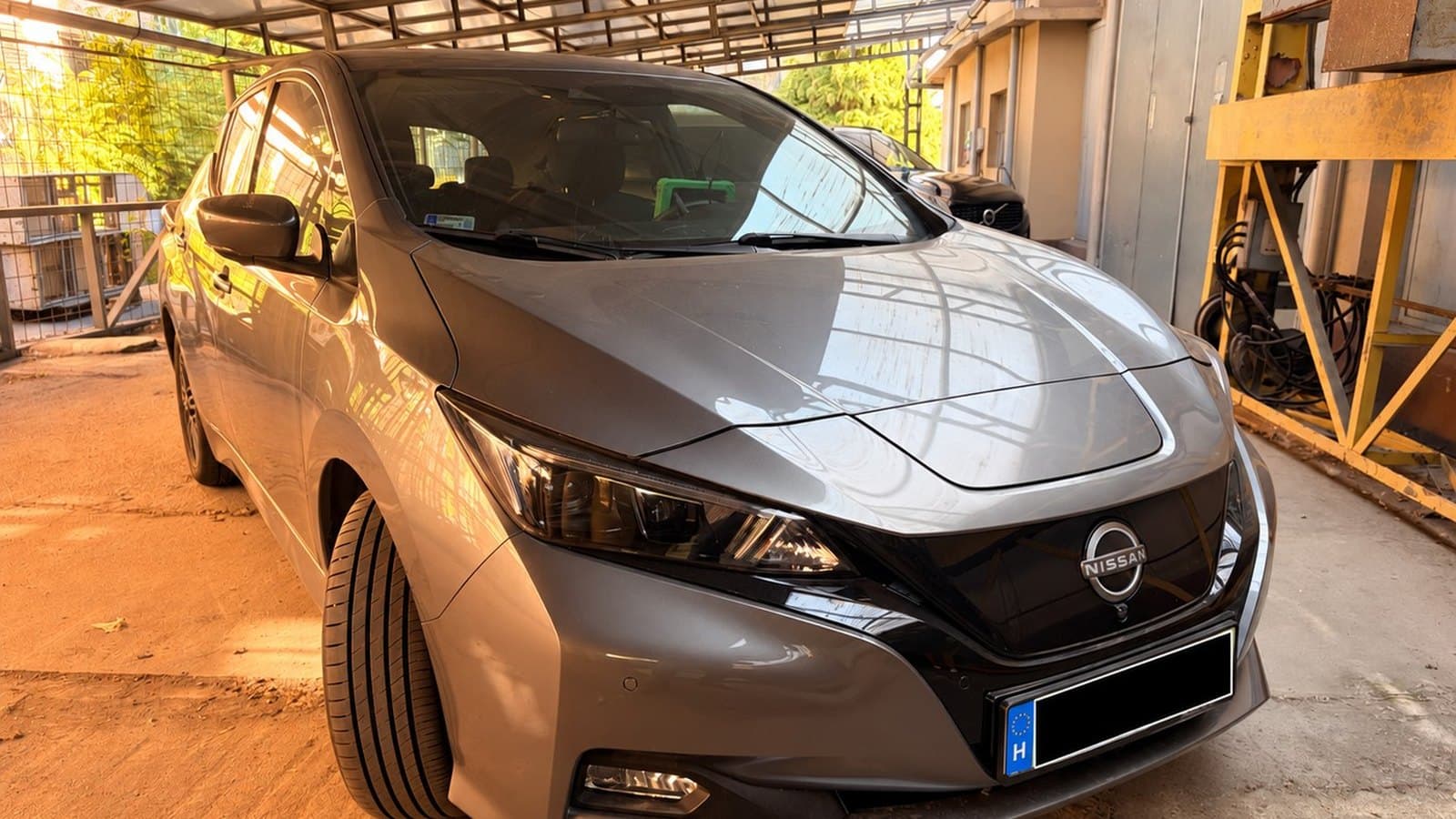 Szürke Nissan Leaf ZE1 elektromos autó a helyszíni AVILOO akkumulátor-diagnosztikán, kitakart rendszámtáblával.