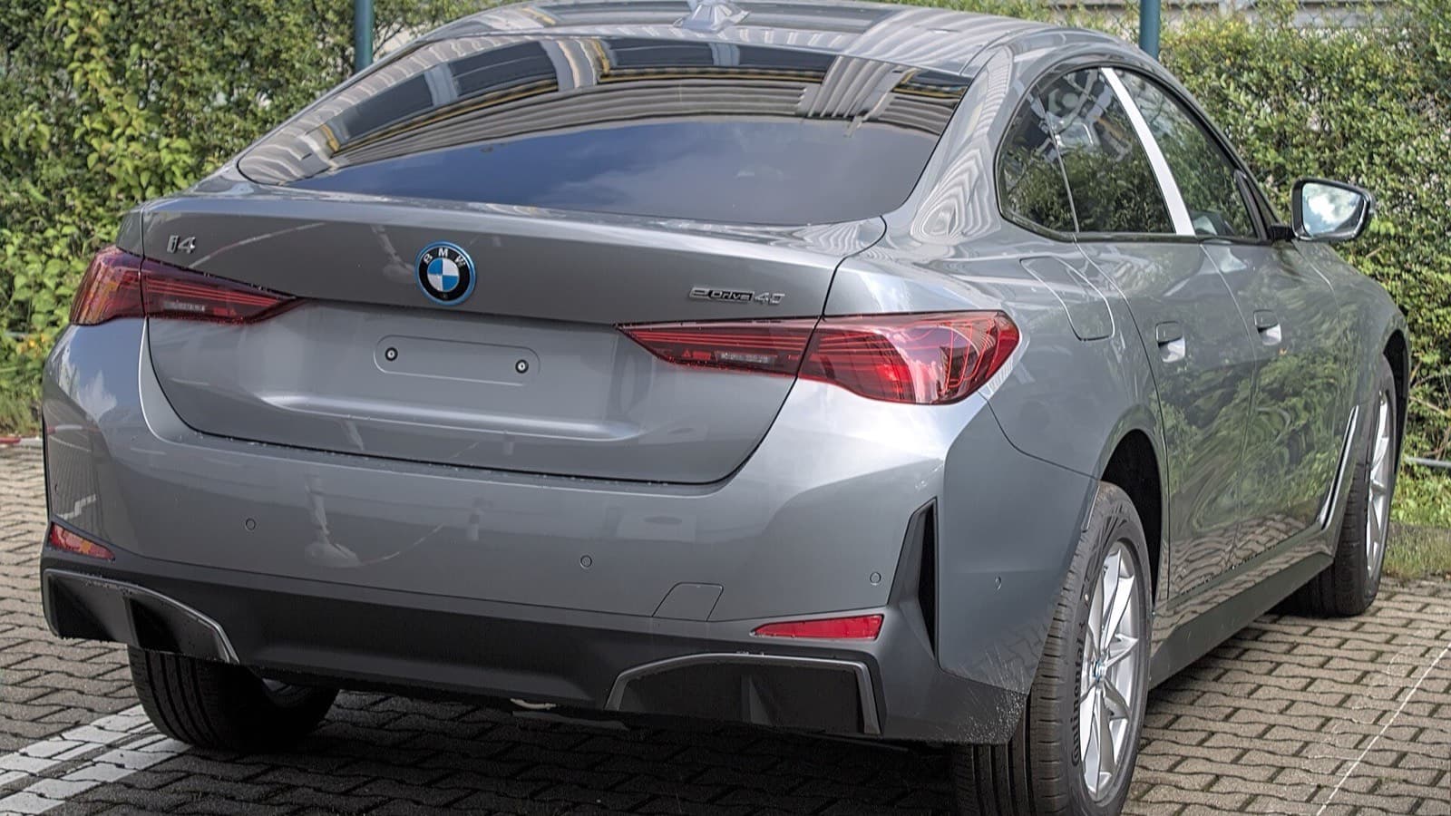 BMW i4 vizsgálati hibák: szürke BMW i4 eDrive40 elektromos autó hátsó nézetben, a visszahívások illusztrációja.