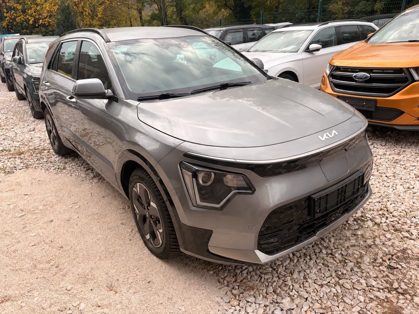 Szürke Kia Niro EV a pest megyei kereskedés telephelyén, anonimizált rendszámmal. — EVX elektromos autó átvizsgálás és állapotfelmérés.