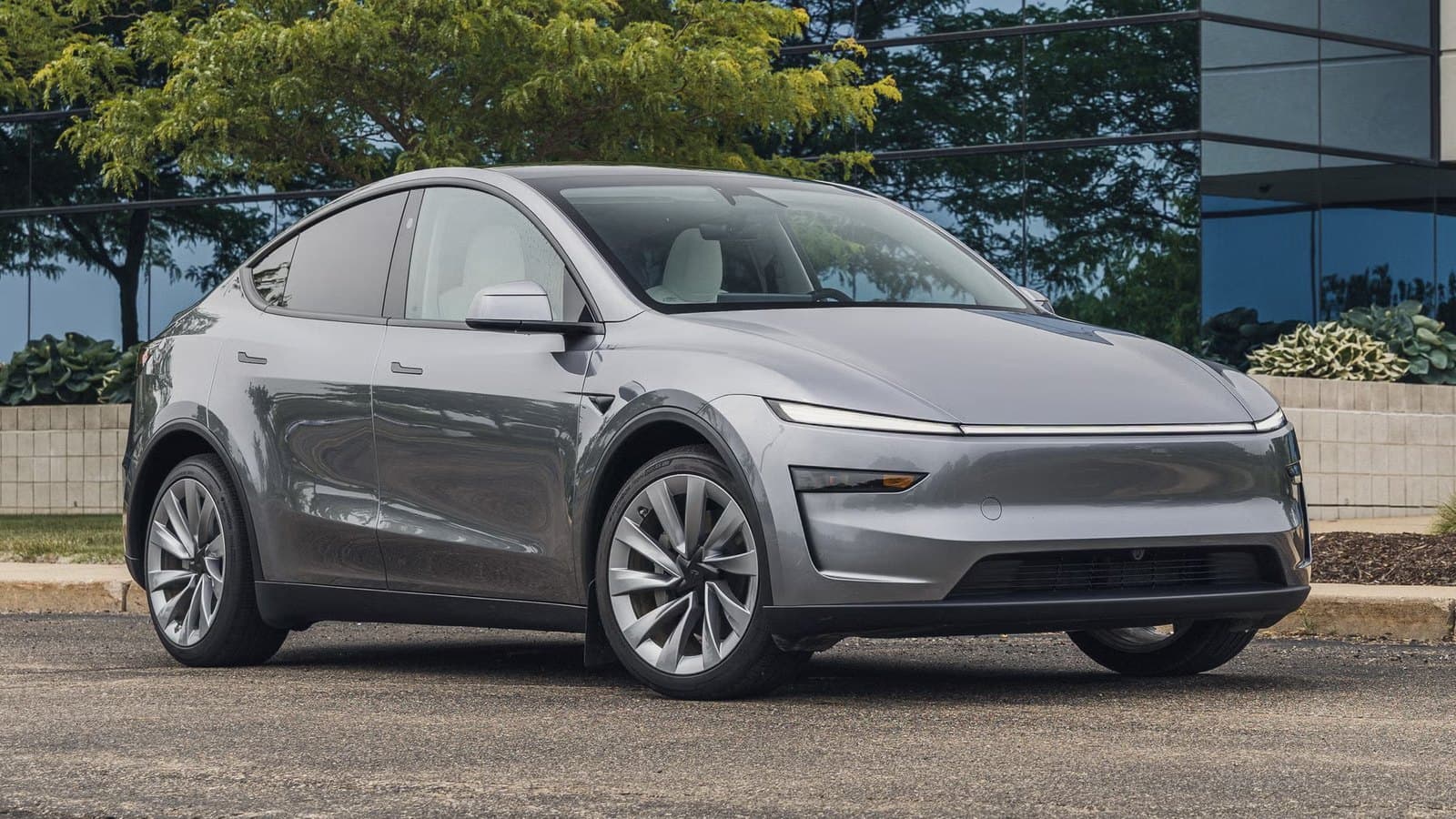 Fehér Tesla Model Y elektromos autó első és oldalsó nézete, a 2026. októberi árcsökkentés híréhez.