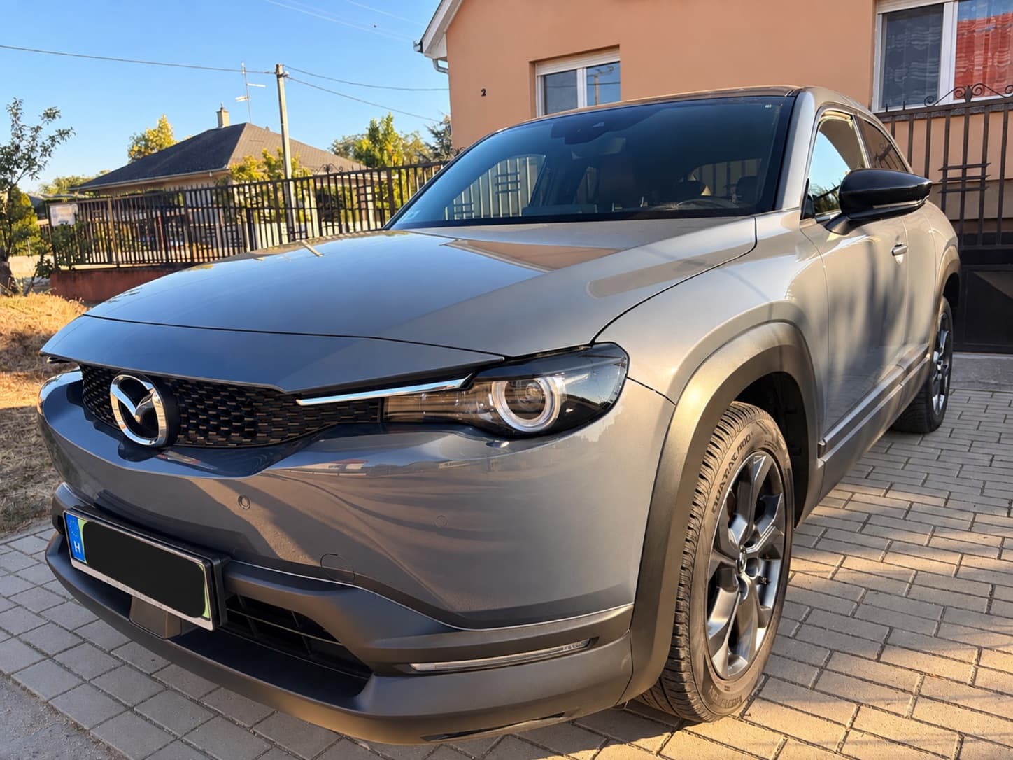 Szürke Mazda MX-30 vásárlás előtti helyszíni állapotfelmérésen, anonimizált rendszámmal.