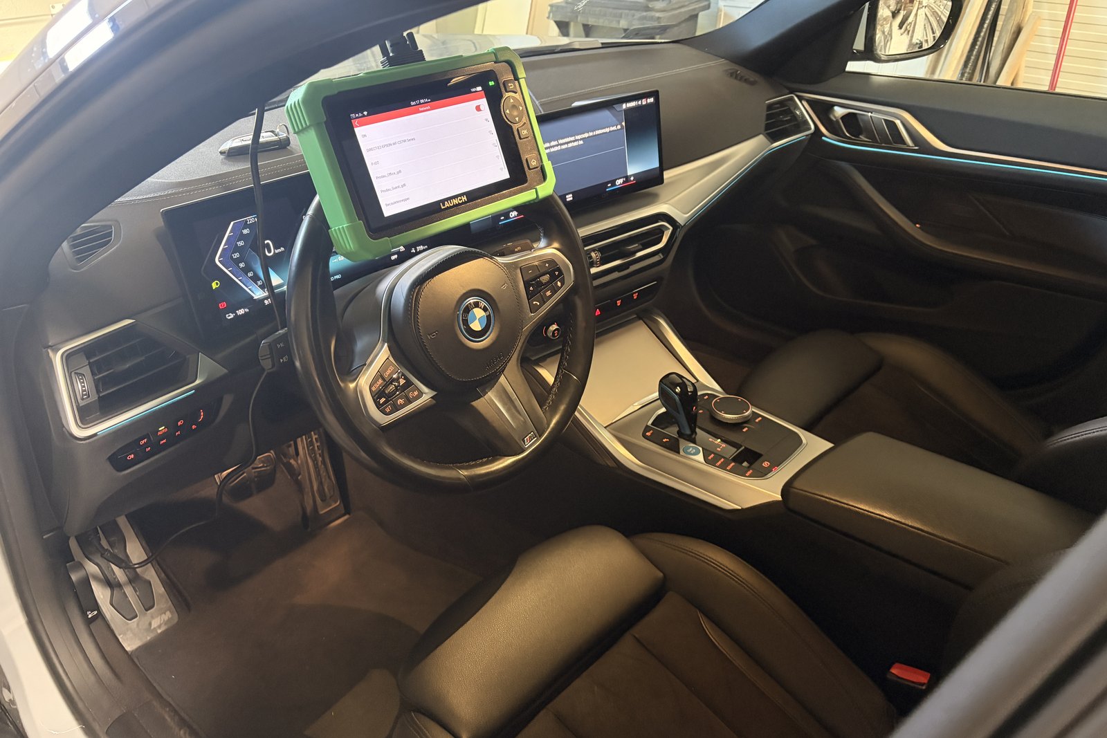 Launch diagnosztikai készülék a BMW i4 utasterében, a hibakód-képernyőn az 5 hibabejegyzéssel, a teljes rendszerlekérdezés közben. — EVX elektromos autó átvizsgálás és állapotfelmérés.