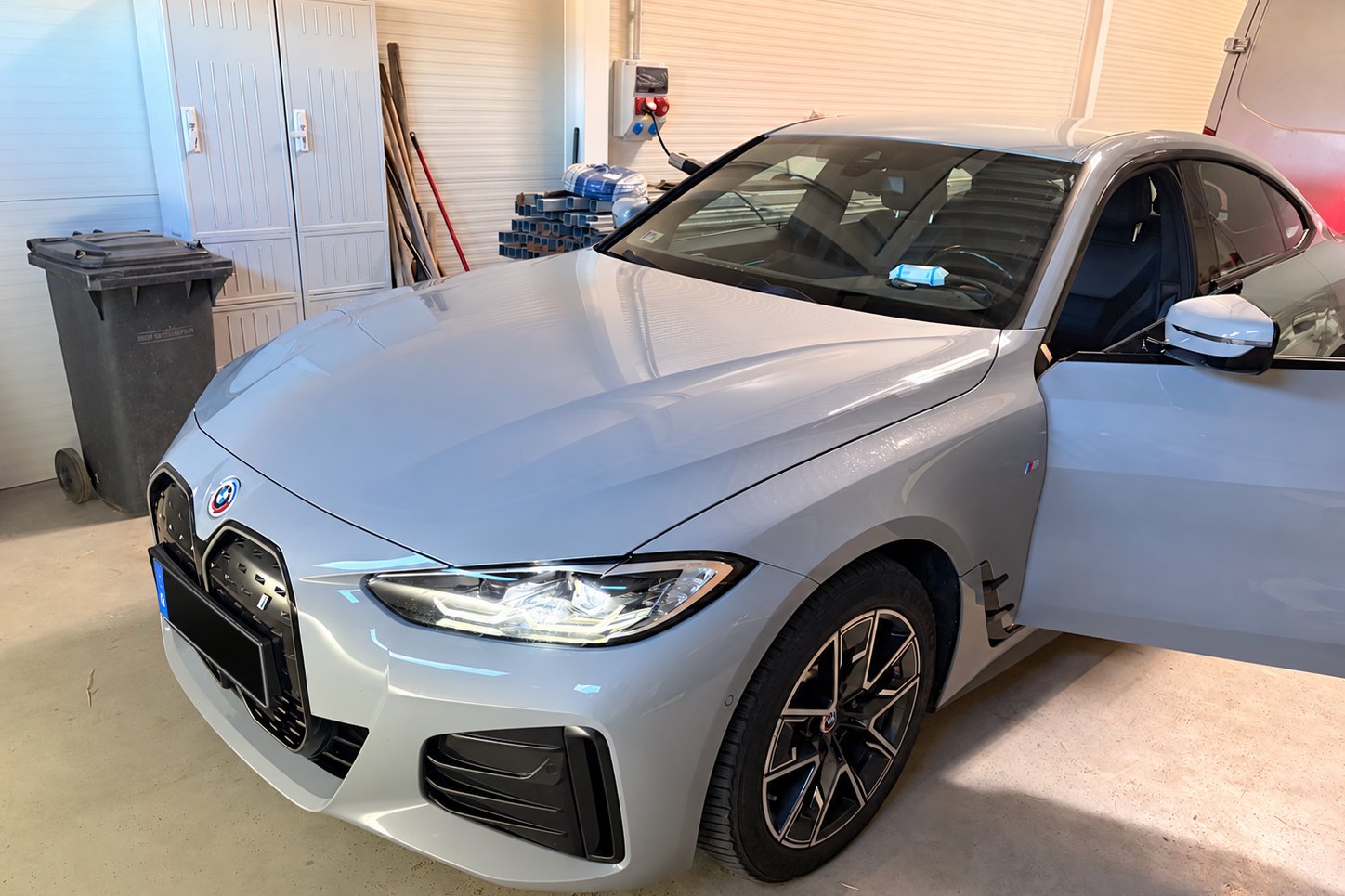 A vizsgált BMW i4 eDrive40 a helyszínen, garázsban, első háromnegyed nézetből, a független állapotfelmérés előtt. — EVX elektromos autó átvizsgálás és állapotfelmérés.